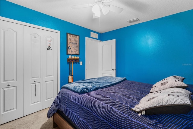 carpeted bedroom featuring a textured ceiling, a closet, and ceiling fan