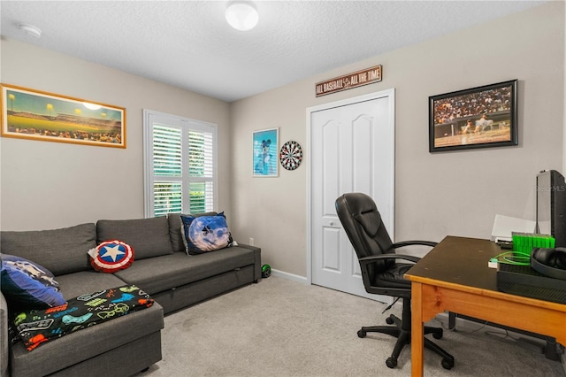 carpeted home office featuring a textured ceiling