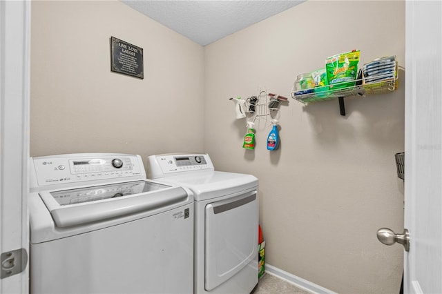 clothes washing area featuring washer and clothes dryer and a textured ceiling