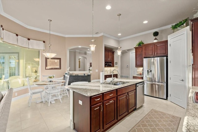 kitchen featuring sink, light stone counters, decorative light fixtures, and stainless steel appliances