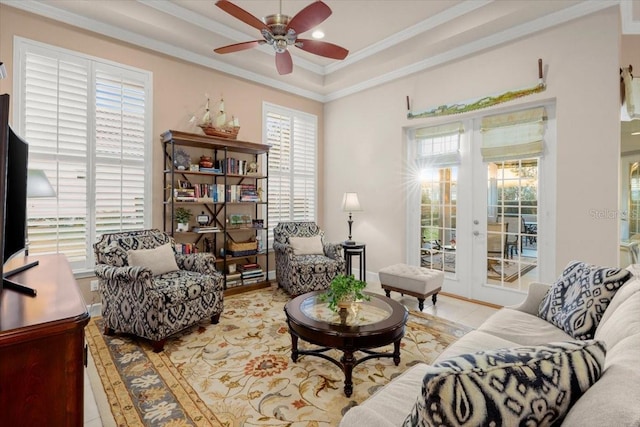 sitting room featuring a wealth of natural light, a raised ceiling, and ornamental molding