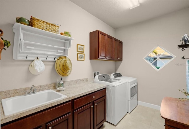 washroom with sink, cabinets, a textured ceiling, and washer and dryer