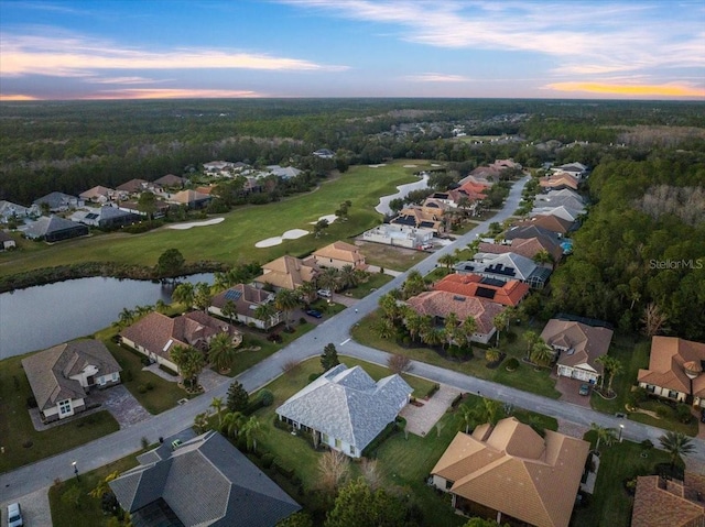 aerial view at dusk featuring a water view