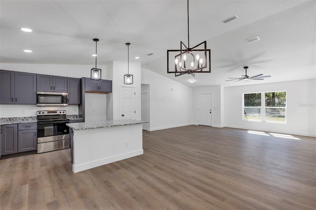 kitchen featuring visible vents, wood finished floors, decorative light fixtures, a center island, and stainless steel appliances