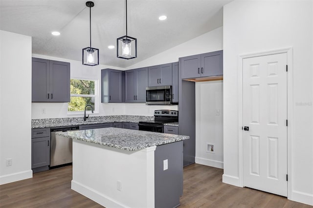 kitchen with dark wood finished floors, stainless steel appliances, lofted ceiling, a sink, and light stone countertops