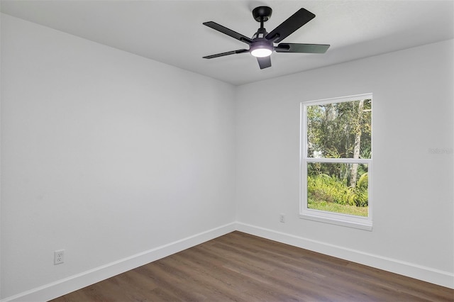 spare room with dark wood-style floors, ceiling fan, and baseboards