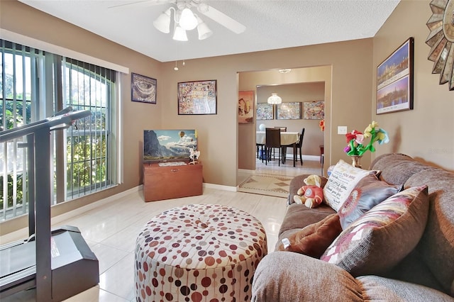 tiled living room featuring ceiling fan and a textured ceiling