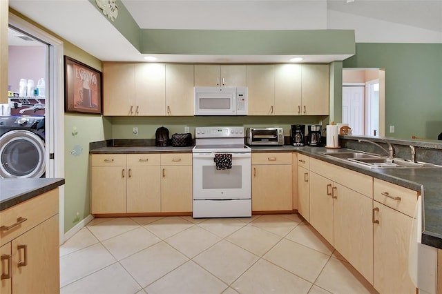 kitchen with sink, light tile patterned floors, white appliances, and washer / dryer