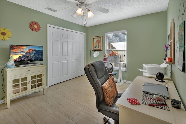 office space featuring ceiling fan, light tile patterned floors, and a textured ceiling