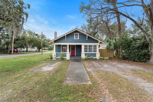 bungalow with covered porch and a front yard