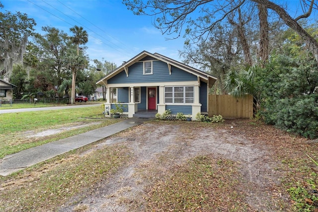 bungalow-style home featuring covered porch and a front yard