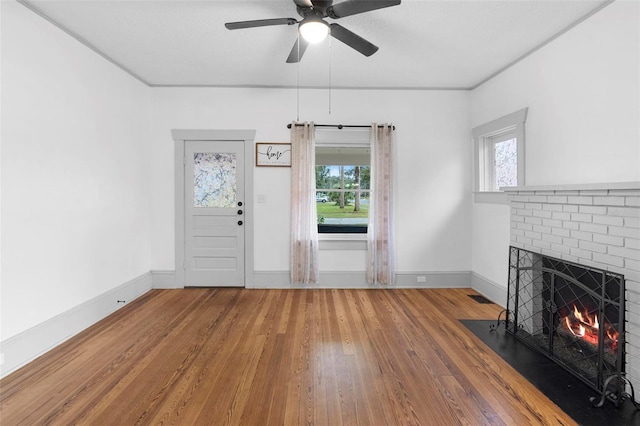 entrance foyer with hardwood / wood-style flooring, plenty of natural light, ceiling fan, and a fireplace