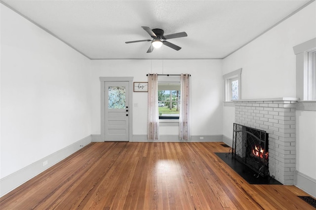 unfurnished living room featuring hardwood / wood-style floors, ceiling fan, and a fireplace