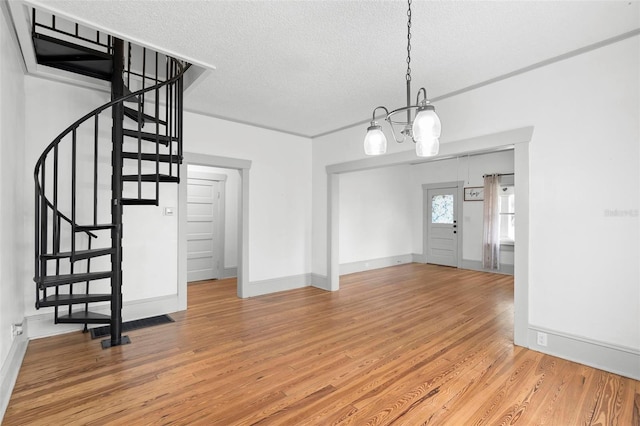 interior space with hardwood / wood-style floors, a textured ceiling, and an inviting chandelier