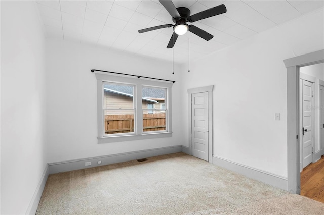 carpeted spare room with ceiling fan