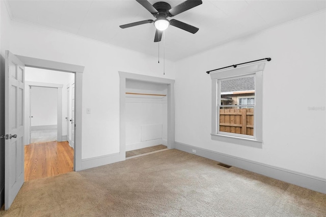 unfurnished bedroom featuring carpet flooring, a closet, ceiling fan, and ornamental molding