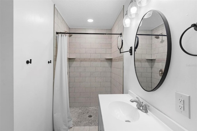 bathroom featuring a textured ceiling, sink, and walk in shower