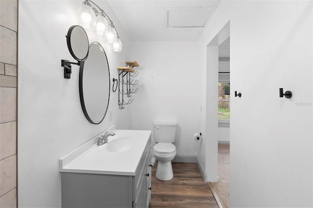 bathroom featuring a textured ceiling, vanity, hardwood / wood-style flooring, and toilet