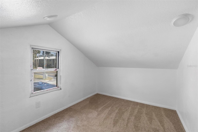 bonus room featuring a textured ceiling, carpet floors, and lofted ceiling