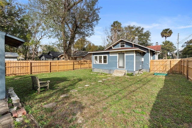 rear view of property featuring a yard