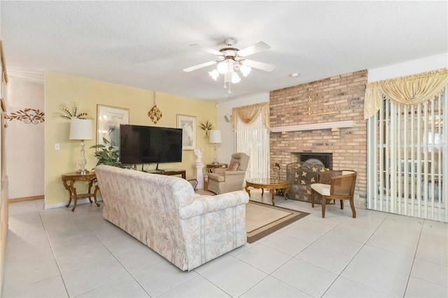 tiled living room with ceiling fan, a textured ceiling, and a brick fireplace