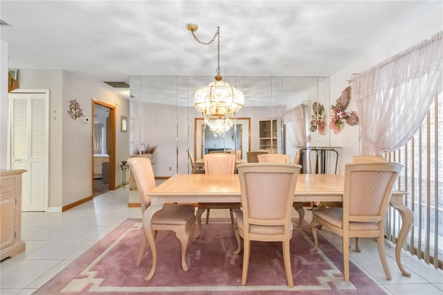 tiled dining room with a chandelier