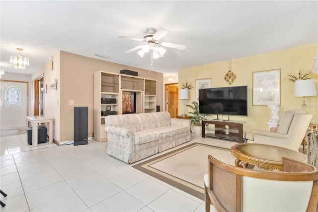 tiled living room featuring a textured ceiling and ceiling fan with notable chandelier