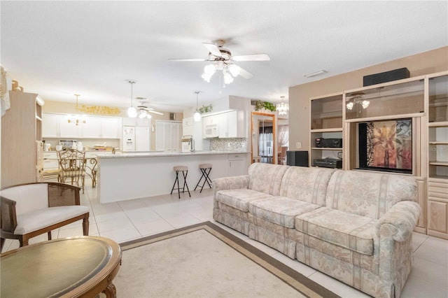 tiled living room featuring a textured ceiling and ceiling fan