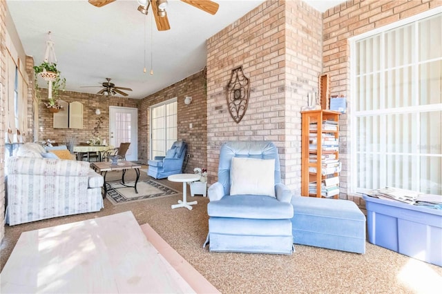 carpeted living room with brick wall