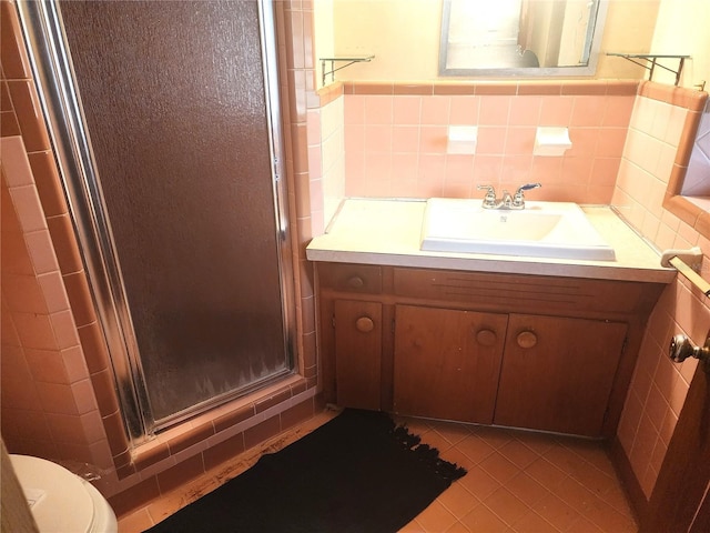 bathroom with tile patterned floors, vanity, toilet, and walk in shower