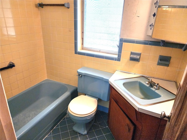 bathroom featuring vanity, a bath, tile patterned flooring, toilet, and tile walls