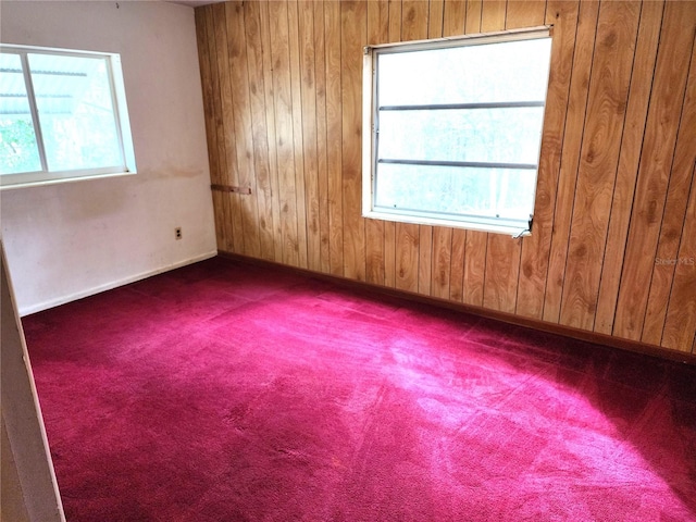 spare room featuring carpet floors and wooden walls