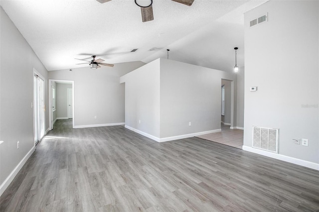 unfurnished living room with ceiling fan, lofted ceiling, hardwood / wood-style floors, and a textured ceiling