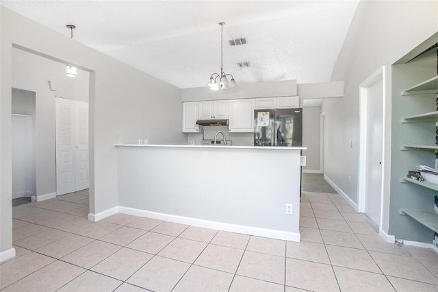 kitchen featuring vaulted ceiling, white cabinetry, hanging light fixtures, light tile patterned floors, and black refrigerator with ice dispenser