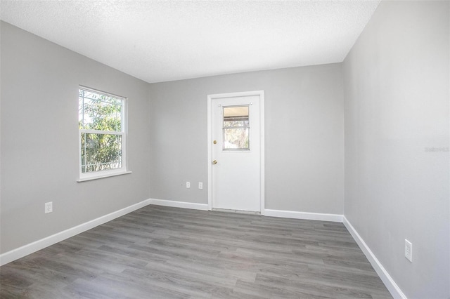 empty room featuring wood-type flooring and a textured ceiling