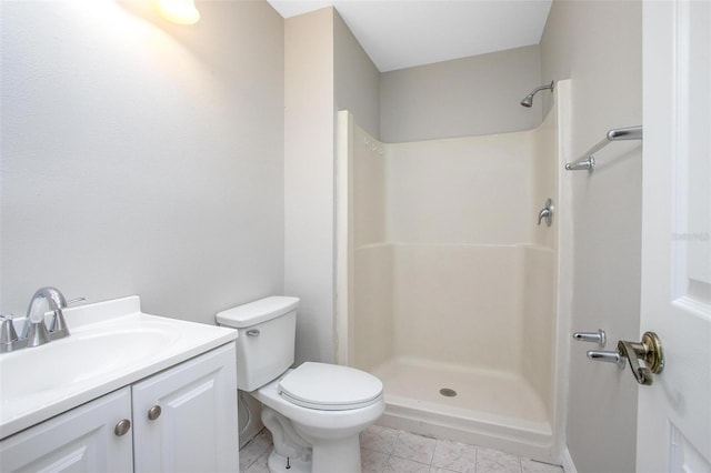 bathroom featuring tile patterned floors, vanity, toilet, and a shower