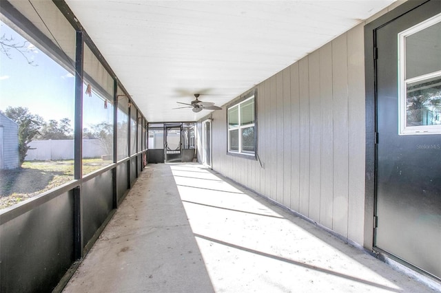 unfurnished sunroom with ceiling fan