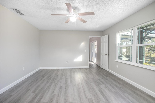 spare room featuring ceiling fan, light hardwood / wood-style floors, and a textured ceiling