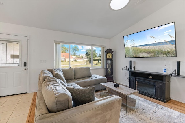 living room featuring light tile patterned flooring and vaulted ceiling