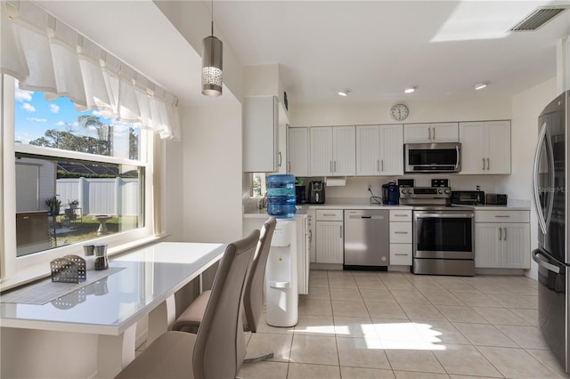 kitchen with pendant lighting, white cabinets, and stainless steel appliances