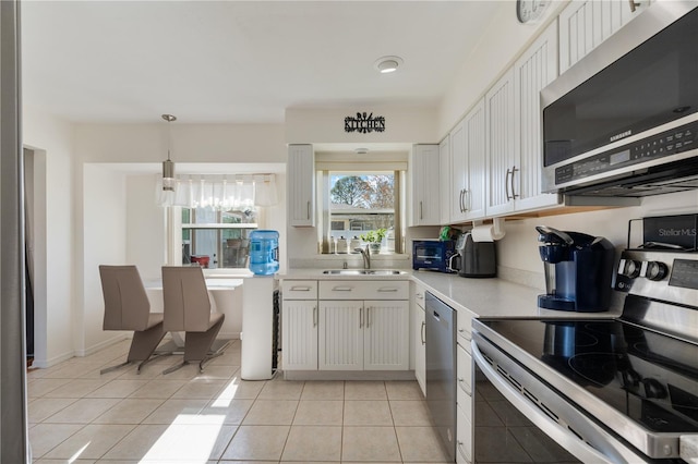 kitchen with sink, white cabinets, light tile patterned floors, and appliances with stainless steel finishes