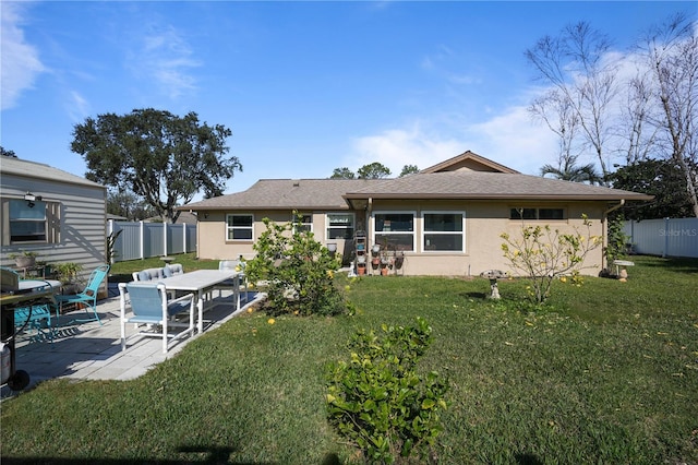 rear view of property with a lawn and a patio area