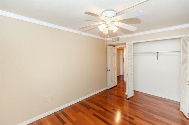 unfurnished bedroom with dark hardwood / wood-style flooring, ceiling fan, a closet, and crown molding