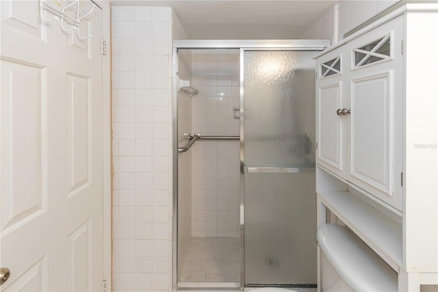 bathroom with toilet and a shower with shower door