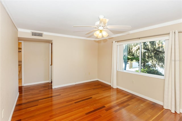 spare room featuring hardwood / wood-style floors, ceiling fan, and crown molding