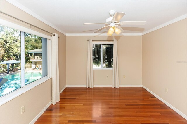 empty room featuring hardwood / wood-style flooring, ceiling fan, and crown molding