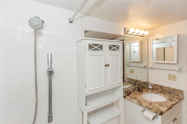 bathroom featuring vanity, a shower, decorative backsplash, and a textured ceiling