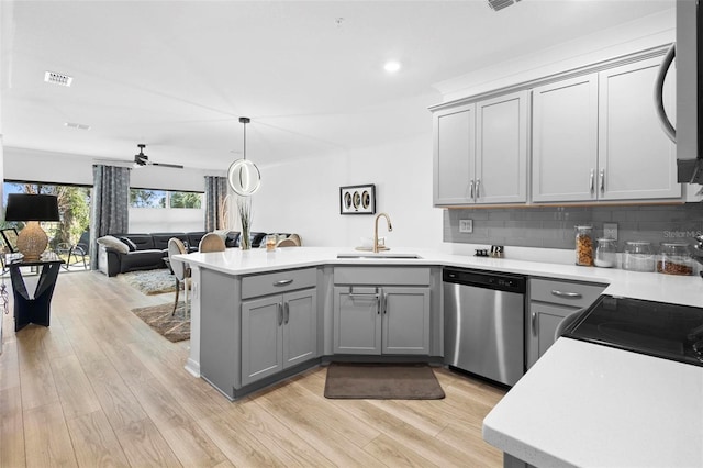 kitchen featuring gray cabinetry, ceiling fan, dishwasher, sink, and kitchen peninsula