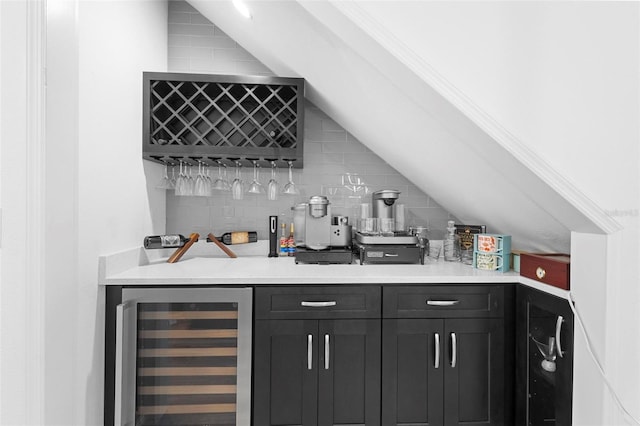 bar featuring decorative backsplash, vaulted ceiling, and beverage cooler