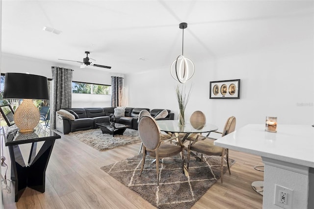 dining space with ceiling fan and light hardwood / wood-style flooring